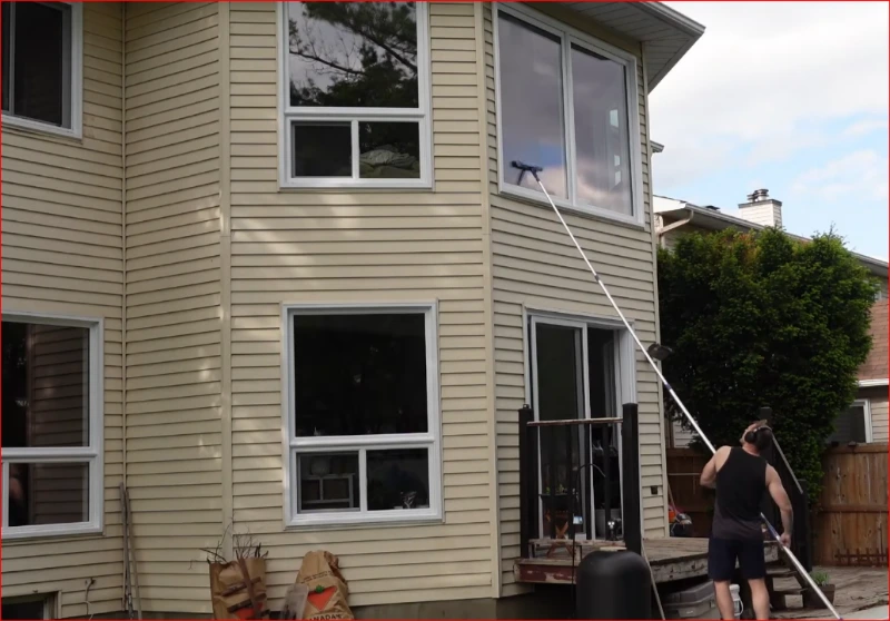 Window cleaning technician squeegeeing a residential window