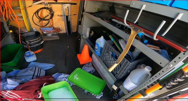 Squeegees, scrapers and cleaning solution laid out for a window cleaning job